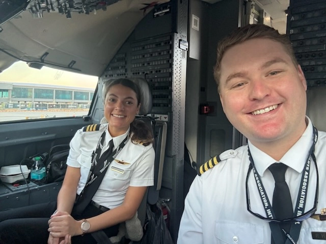 Former Speedway students Katrina and Preston smiling together in an airline cockpit